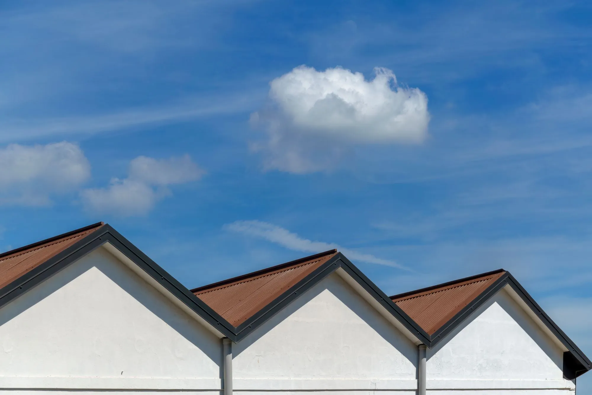A row of pitched gables against a bright sky