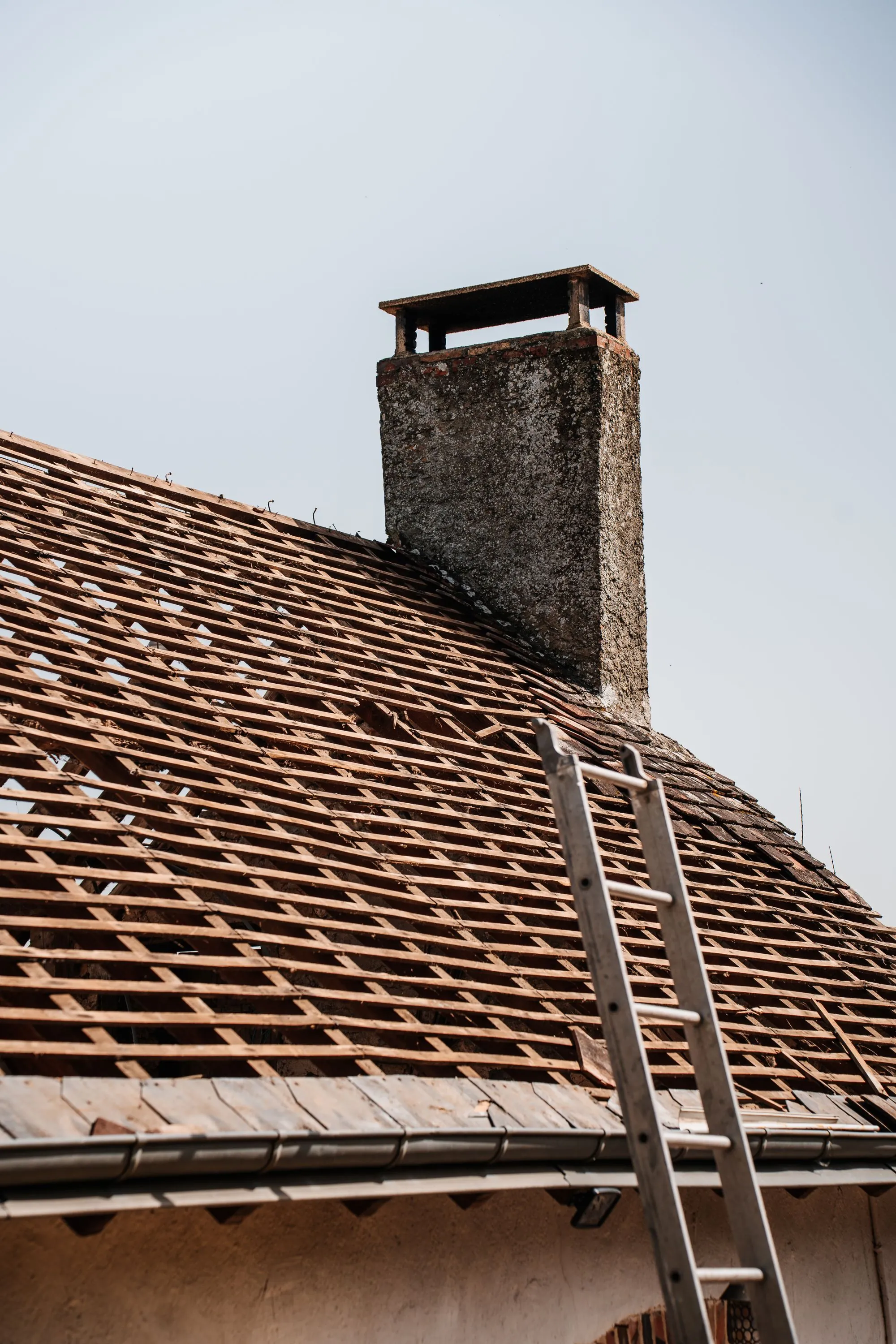 A ladder resting against a roof being re-covered